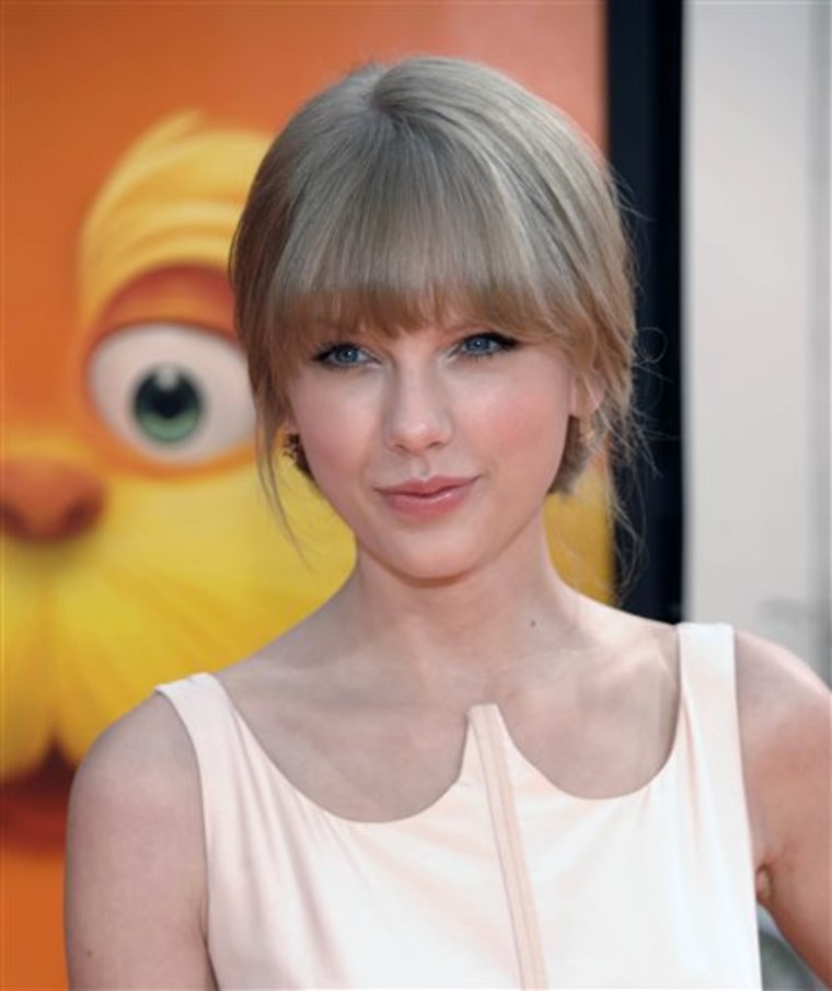 In this Feb. 19, 2012 photo, Taylor Swift arrives at the premiere of the animated feature film \"The Lorax\" in Universal City, Calif. Taylor Swift has a date for the Academy of Country Music awards.  The country star asked a fan, Kevin McGuire of Somerdale, N.J., to the awards show. McGuire is 18 and has leukemia (AP Photo/Dan Steinberg)